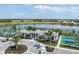 Aerial view of a pool and amenity center nestled beside a lake in a lushly landscaped community at 18059 Cherished Loop, Bradenton, FL 34211