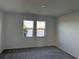 Bright bedroom with gray carpet and double windows overlooking the lake at 18059 Cherished Loop, Bradenton, FL 34211