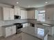 Modern kitchen with white cabinets, granite island, and stainless steel appliances at 18059 Cherished Loop, Bradenton, FL 34211