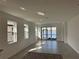 Bright living room featuring tile floors, large windows, and sliding glass doors with lake views at 18059 Cherished Loop, Bradenton, FL 34211
