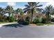 Community clubhouse with palm trees and driveway at 206 Bella Vista Ter # 29B, North Venice, FL 34275