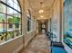 Long hallway with arched windows and artwork at 206 Bella Vista Ter # 29B, North Venice, FL 34275