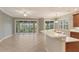 Spacious kitchen with breakfast bar, tile flooring, and sliding doors to patio at 206 Bella Vista Ter # 29B, North Venice, FL 34275