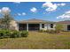 Home's backyard featuring a screened lanai, green lawn, and well-maintained landscaping at 2164 Midnight Pearl Dr, Sarasota, FL 34240