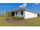 Exterior view of a white home featuring a green lawn and manicured landscaping at 2164 Midnight Pearl Dr, Sarasota, FL 34240
