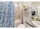 Well-lit bathroom with tile floors, granite countertop vanity, and a charming shower with a blue patterned curtain at 2164 Midnight Pearl Dr, Sarasota, FL 34240