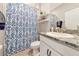 Bright bathroom with granite countertop vanity, a decorative mirror, and a charming shower curtain at 2164 Midnight Pearl Dr, Sarasota, FL 34240