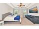 Spacious bedroom featuring a queen bed, dresser, sofa, and a large television at 2164 Midnight Pearl Dr, Sarasota, FL 34240