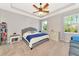 Bright bedroom with a tray ceiling, a queen bed, two windows and a dresser at 2164 Midnight Pearl Dr, Sarasota, FL 34240