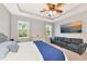 Bright, well-lit bedroom featuring large bed, dresser, couch, and a mounted television at 2164 Midnight Pearl Dr, Sarasota, FL 34240