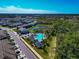 Aerial shot of a community with a pool, clubhouse, and nearby pond surrounded by trees and homes at 2164 Midnight Pearl Dr, Sarasota, FL 34240