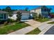 Home featuring a two-car garage, manicured landscaping, and a well-maintained lawn at 2164 Midnight Pearl Dr, Sarasota, FL 34240
