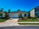 Home featuring a two-car garage, manicured landscaping, and a well-maintained lawn at 2164 Midnight Pearl Dr, Sarasota, FL 34240