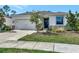 Inviting single-story home featuring a well-kept lawn, stone accents, and an attached two car garage at 2164 Midnight Pearl Dr, Sarasota, FL 34240