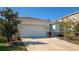 Home featuring a two-car garage, manicured landscaping, and a well-maintained lawn at 2164 Midnight Pearl Dr, Sarasota, FL 34240
