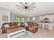 Cozy living room with a large leather couch, decorative pillows, and a modern ceiling fan at 2164 Midnight Pearl Dr, Sarasota, FL 34240