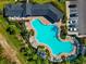 Aerial view of a large community pool featuring lounge chairs, landscaping, and a clubhouse at 2164 Midnight Pearl Dr, Sarasota, FL 34240