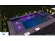 Evening shot of a modern rectangular pool and spa with ambient lighting and manicured landscaping at 2164 Midnight Pearl Dr, Sarasota, FL 34240