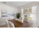 Bright dining room features a wood table, white chairs, and large window with backyard view at 2200 Pratt Avenue, North Port, FL 34286
