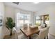 Bright dining room with wooden table, white chairs, and view of backyard at 2200 Pratt Avenue, North Port, FL 34286