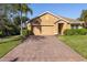 Tan house with paved driveway and landscaping at 2200 Pratt Avenue, North Port, FL 34286