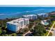 Aerial view of waterfront condos with manicured lawns, pool, and beautifully maintained landscaping at 2550 Harbourside Dr # 322, Longboat Key, FL 34228