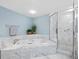 Modern bathroom featuring tub, shower, tile accents, and light blue wall paint at 2550 Harbourside Dr # 322, Longboat Key, FL 34228