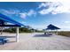 Inviting picnic area with blue tables on a white sandy beach near residential buildings at 2550 Harbourside Dr # 322, Longboat Key, FL 34228