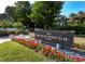 Stone monument sign at Bay Isles Beach Club featuring red flowers in front of the entrance at 2550 Harbourside Dr # 322, Longboat Key, FL 34228