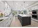 Bright and airy kitchen with a large island, seating, stainless appliances, and views into the living area at 2550 Harbourside Dr # 322, Longboat Key, FL 34228