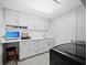 Well-lit laundry room featuring sink, counter space, white cabinets, and overhead lighting at 2550 Harbourside Dr # 322, Longboat Key, FL 34228