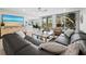 Open-concept living area with a large sectional sofa, a modern entertainment center, and balcony access at 2550 Harbourside Dr # 322, Longboat Key, FL 34228