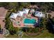 Aerial view of pool and spa area with lounge chairs, cabanas, lush landscaping, and brick pavers at 2550 Harbourside Dr # 322, Longboat Key, FL 34228