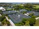 Aerial view of tennis courts nestled among lush greenery and landscaping, offering a private and serene playing experience at 2550 Harbourside Dr # 322, Longboat Key, FL 34228