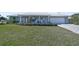 Landscaped front yard with a spacious lawn and paver driveway at 308 Matisse E Cir, Nokomis, FL 34275