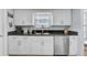 Clean kitchen with white cabinets, stainless steel dishwasher, and granite countertops at 308 Matisse E Cir, Nokomis, FL 34275