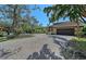Expansive brick driveway leading to a well-maintained home surrounded by mature trees and lush landscaping at 3131 Bayou Sound, Longboat Key, FL 34228