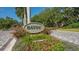 Beautifully landscaped entrance sign to the Bayou neighborhood with colorful flowers and lush greenery at 3131 Bayou Sound, Longboat Key, FL 34228