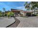 Inviting exterior featuring a tile roof, palm trees, beautiful landscaping, brick driveway, and attached garage at 3131 Bayou Sound, Longboat Key, FL 34228