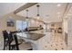 Well-lit eat-in kitchen with stainless steel appliances, a breakfast bar, and modern hanging lights at 3131 Bayou Sound, Longboat Key, FL 34228