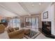 Bright living room with fireplace, bar cart, beamed ceilings, and sliding doors to the outdoor patio at 3131 Bayou Sound, Longboat Key, FL 34228