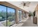 Bright sunroom with tile flooring, ceiling fan, large glass sliding doors, and views of the outdoor scenery at 3131 Bayou Sound, Longboat Key, FL 34228
