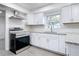 Updated kitchen with white cabinets, granite counters, and stainless steel range at 3419 27Th Pkwy, Sarasota, FL 34235