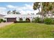 Single-story home with a white exterior, red door, and manicured lawn at 3746 Torrey Pines Blvd, Sarasota, FL 34238