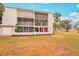 Two-story condo building with screened balconies and a landscaped yard at 404 Cerromar N Cir # 108, Venice, FL 34293