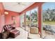Sunroom with terracotta walls and access to a patio with a view at 404 Cerromar N Cir # 108, Venice, FL 34293