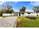 Updated home exterior boasts a paved driveway and landscaped lawn at 4042 Radnor Pl, Sarasota, FL 34233
