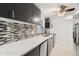 Sleek kitchen with gray cabinets, quartz countertops, and mosaic backsplash at 4042 Radnor Pl, Sarasota, FL 34233