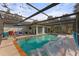 Enclosed pool area with a covered patio and lush landscaping at 4363 Melis St, Port Charlotte, FL 33948