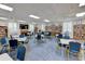 Bright community room with tables, chairs, and bookshelves at 4799 Independence Dr, Bradenton, FL 34210